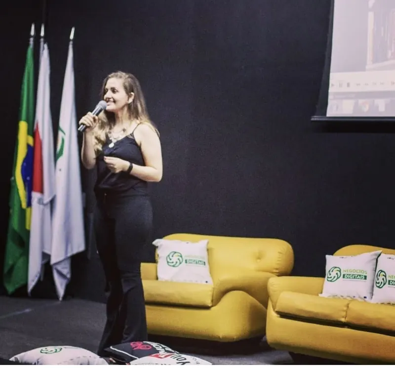 Osmarina palestrando em um palco com microfone